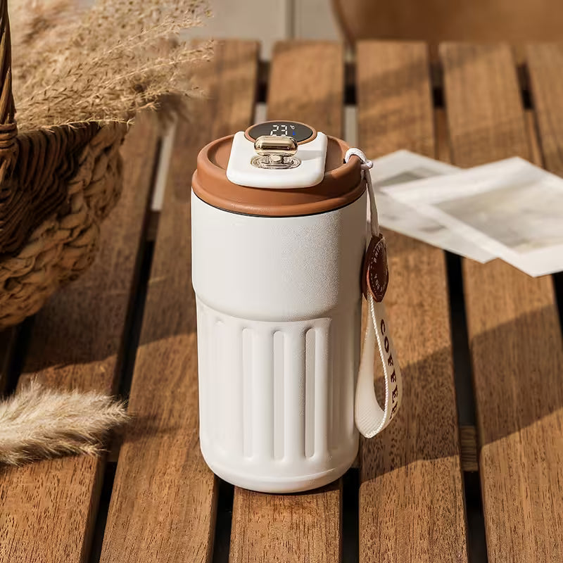 White travel mug with brown lid on a wooden surface