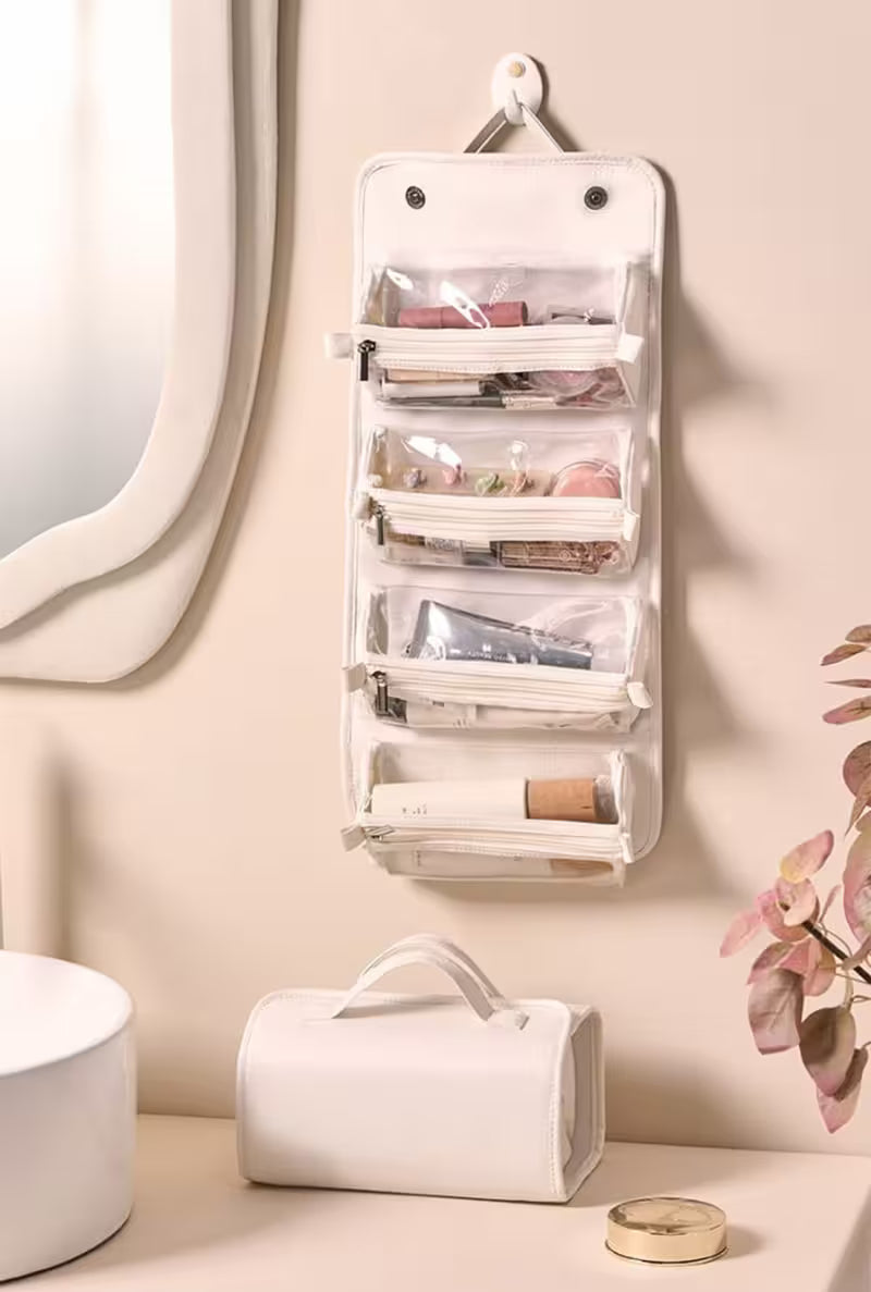 Wall-mounted hanging organizer with beauty products on a neutral wall.