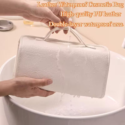White cosmetic bag being held above a sink with water dripping off, highlighting its waterproof feature.