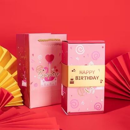 Pink gift bag and box with 'Happy Birthday' text on a red background