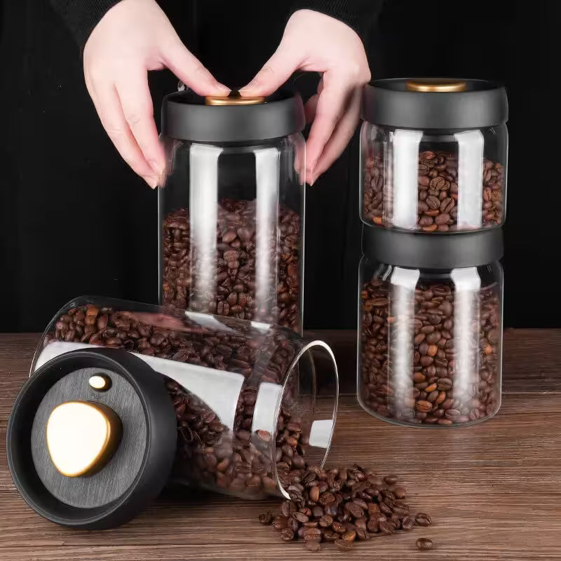Glass jars with black lids filled with coffee beans on a wooden surface.