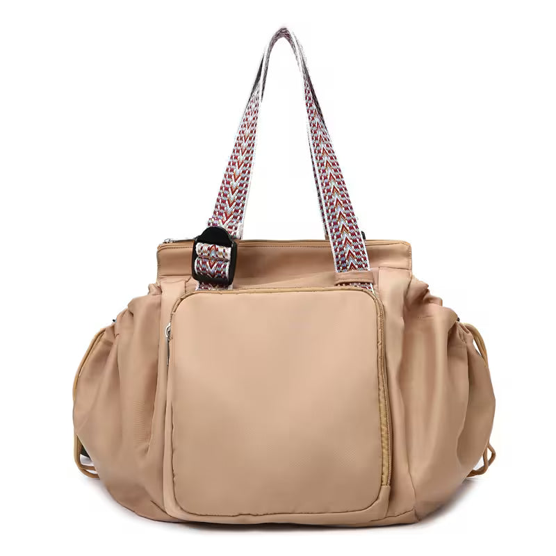 Beige handbag with patterned handle on a white background