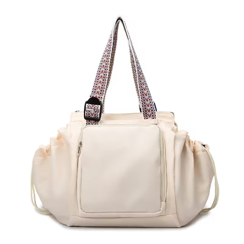 Beige handbag with a patterned strap on a white background