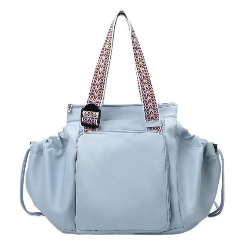 Light blue handbag with a patterned strap on a white background