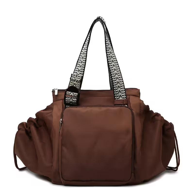 Brown handbag with a patterned handle on a white background