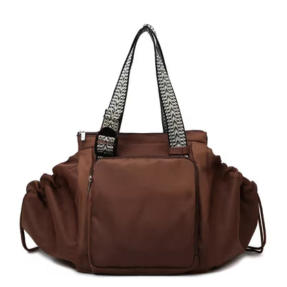 Brown handbag with a patterned handle on a white background