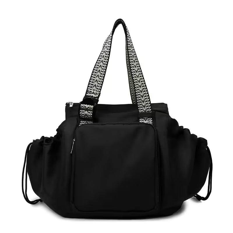 Black handbag with patterned handles on a white background