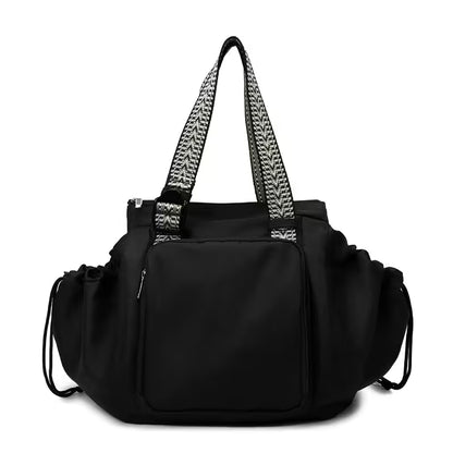 Black handbag with patterned handles on a white background