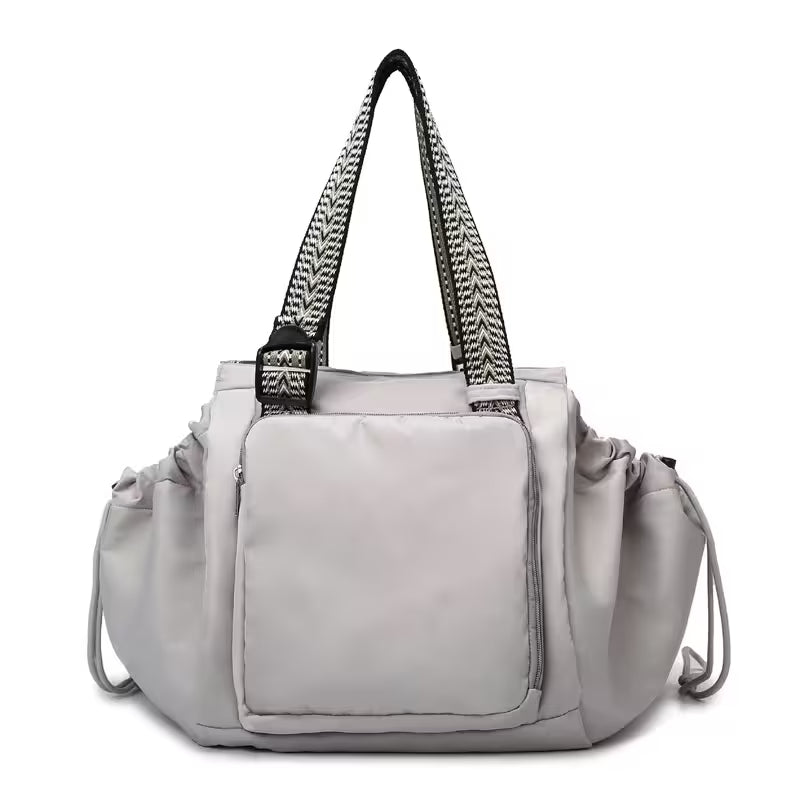 Gray handbag with black straps on a white background