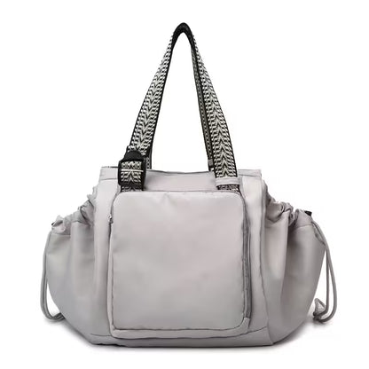Gray handbag with black straps on a white background