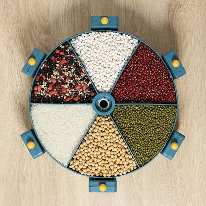 Round container with compartments filled with various types of grains and seeds on a wooden surface.