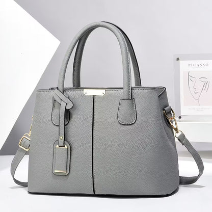 Gray handbag with gold accents on a white background