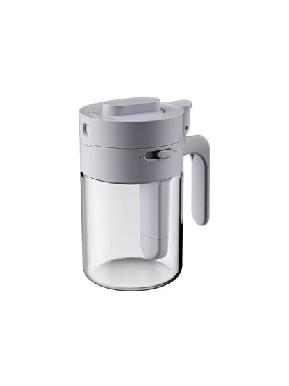 Clear glass pitcher with gray lid and handle on a white background