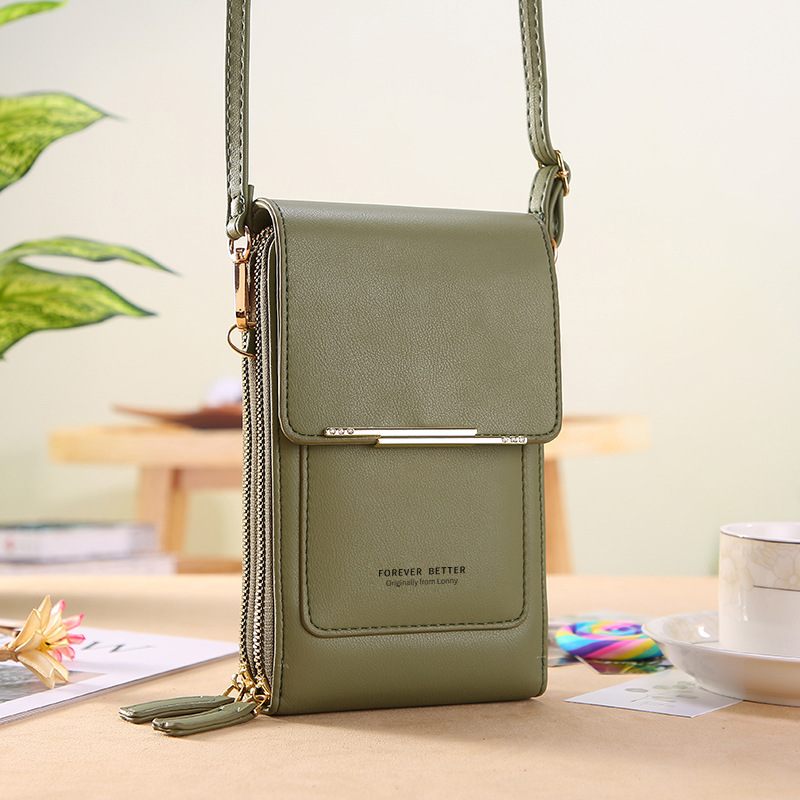Green crossbody bag on a table with a blurred background