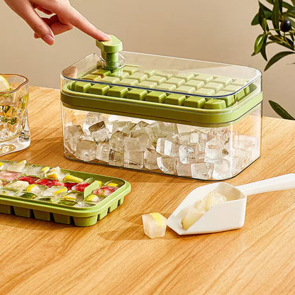 Green ice cube tray with clear container on a wooden table, filled with ice cubes.