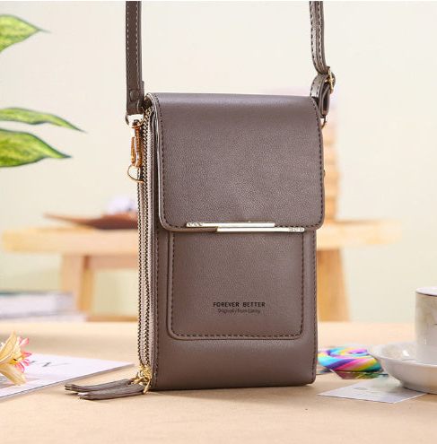 Gray crossbody bag on a table with a blurred background
