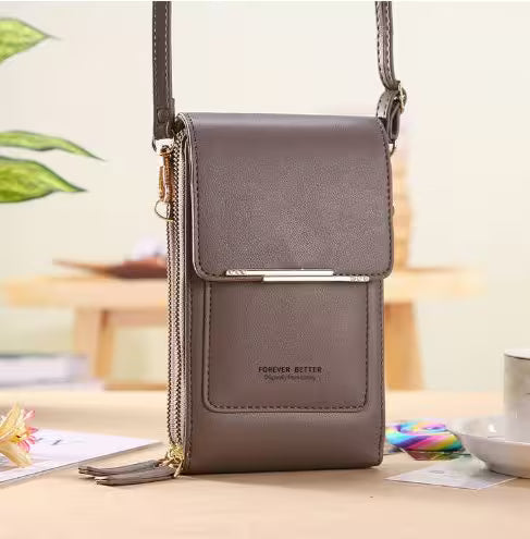 Gray crossbody bag on a table with a blurred indoor background