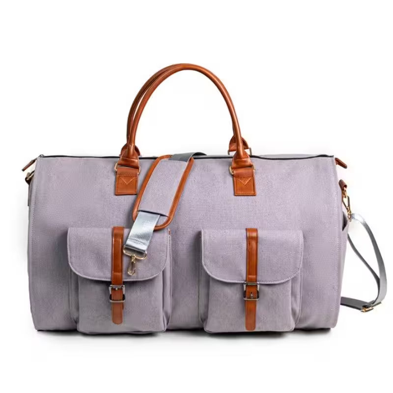 Gray duffel bag with brown leather straps on a white background