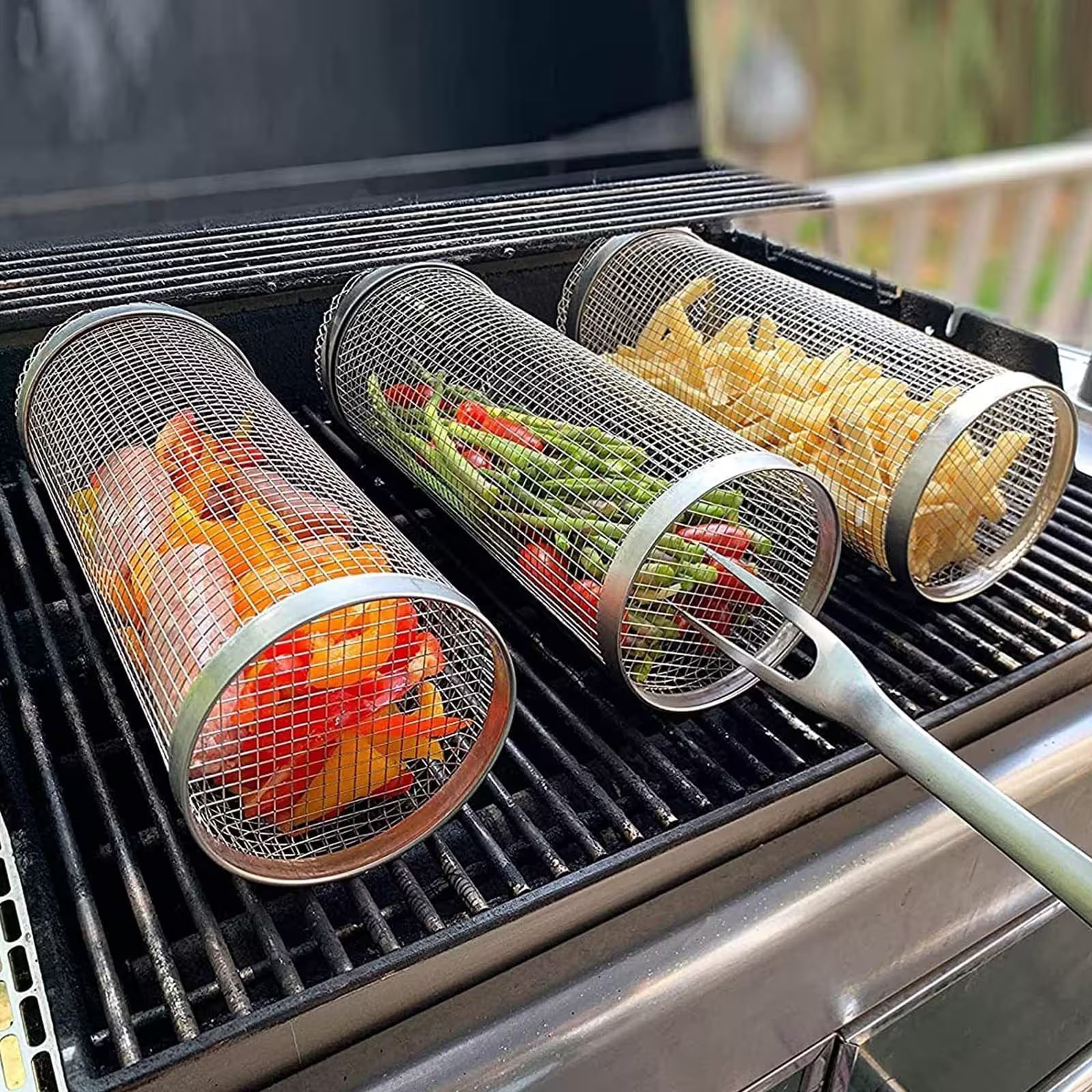 Metal mesh vegetable grilling baskets with vegetables on a grill