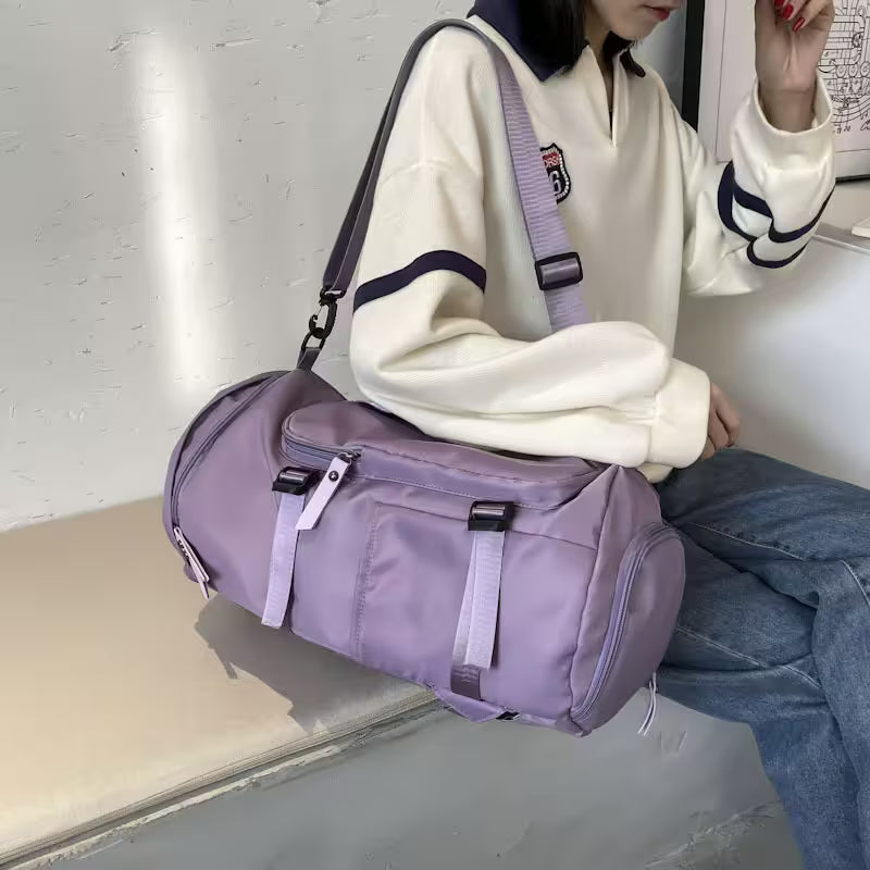 Person sitting with a purple duffel bag on a bench