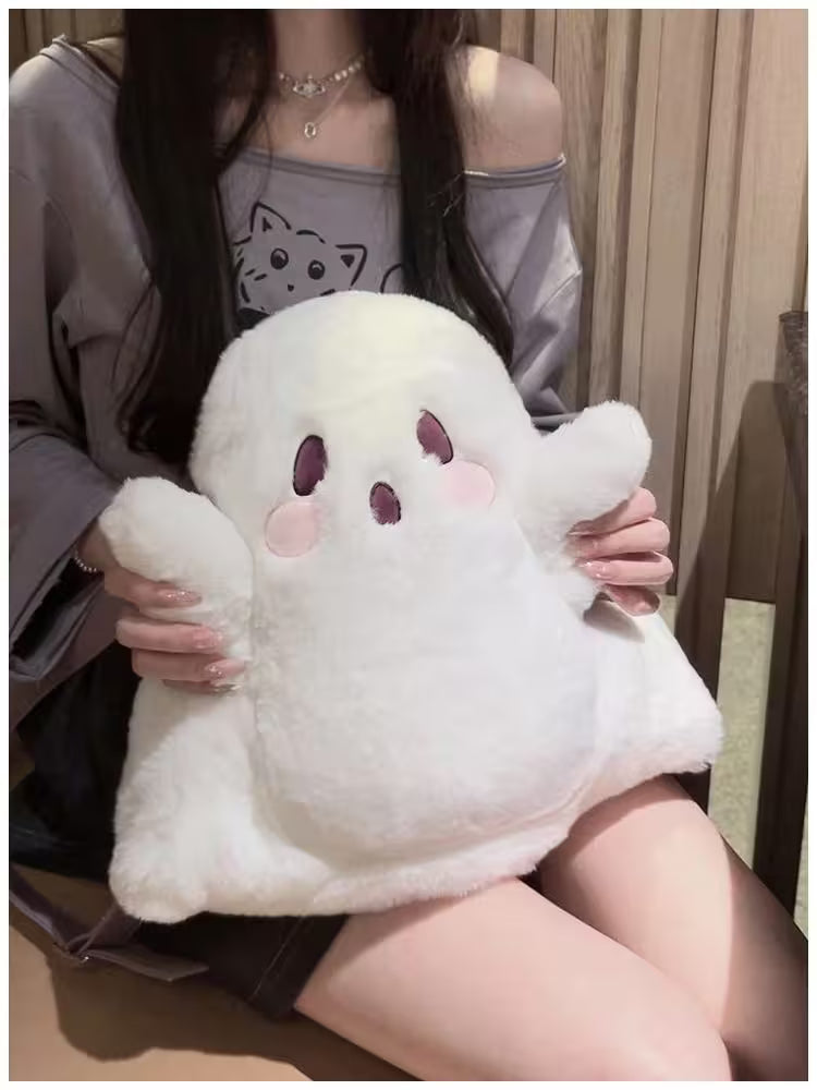 Person holding a plush ghost toy with a neutral background