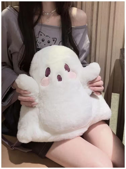 Person holding a plush ghost toy with a neutral background