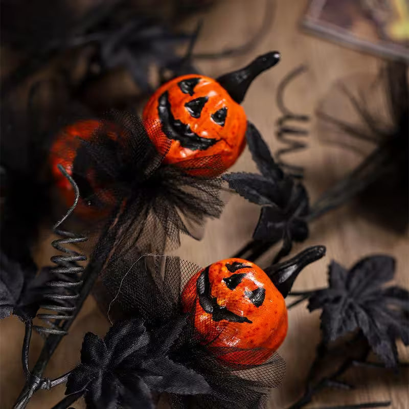 Halloween-themed decorations with jack-o'-lanterns and black ribbons on a dark background.