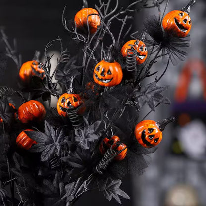 Halloween-themed decorative arrangement with jack-o'-lanterns on black branches against a dark background.