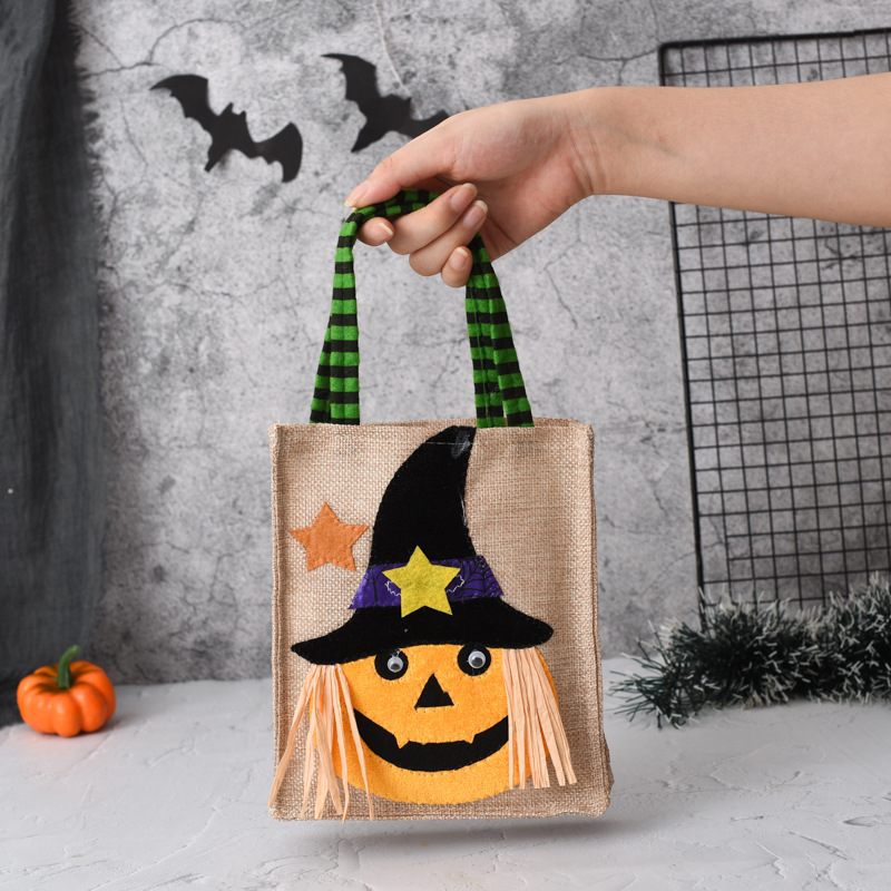 Halloween-themed small bag with a pumpkin design and witch hat, held by a hand against a Halloween-themed background.
