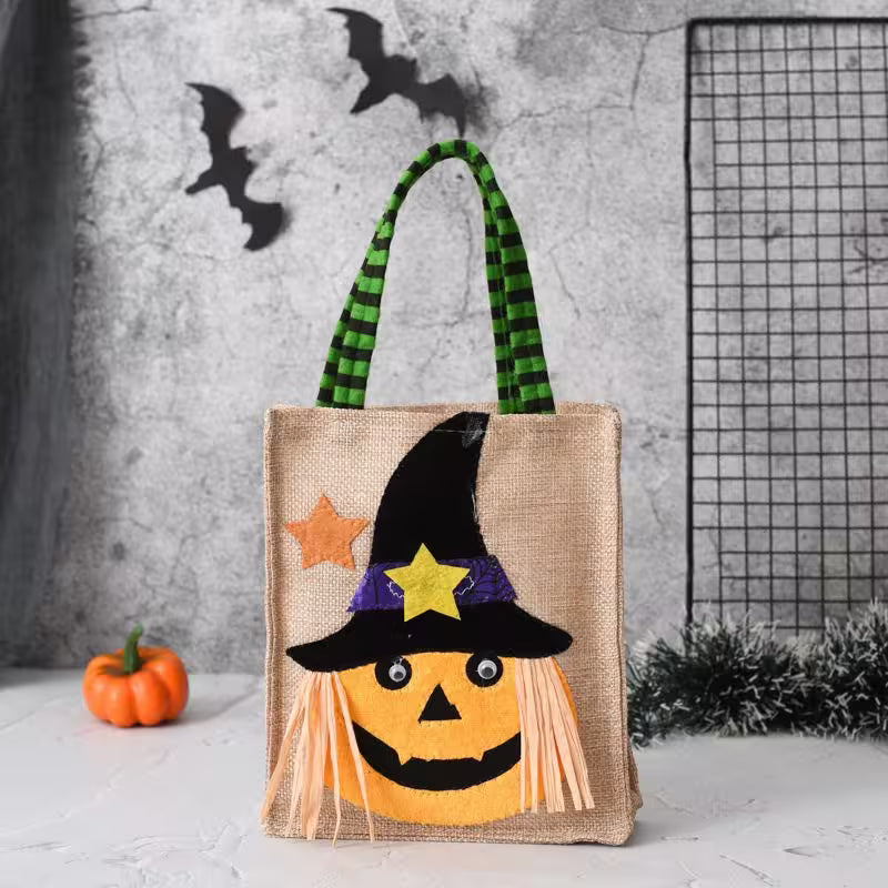 Halloween-themed tote bag with pumpkin design and witch hat against a textured wall background.