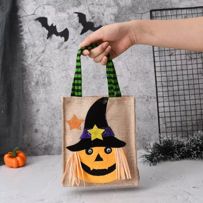 Halloween-themed bag with a pumpkin face design held by a hand against a neutral background.