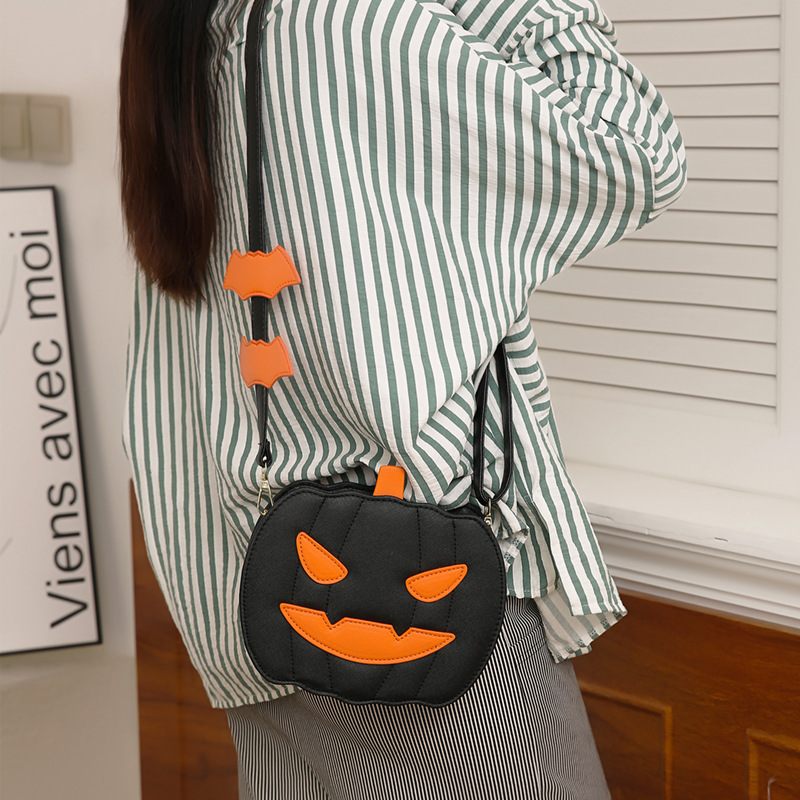 Person wearing a striped shirt with a Halloween-themed black and orange bag.