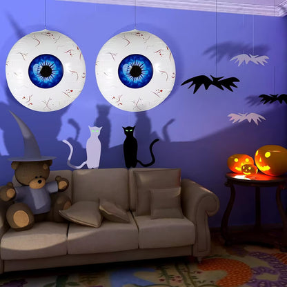 Halloween-themed room with eyeball decorations, pumpkins, and spooky shadows on a purple wall.