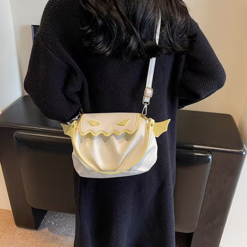 Person holding a gold and white handbag with cat ears design.
