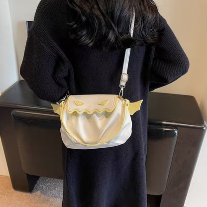 Person holding a gold and white handbag with cat ears design.