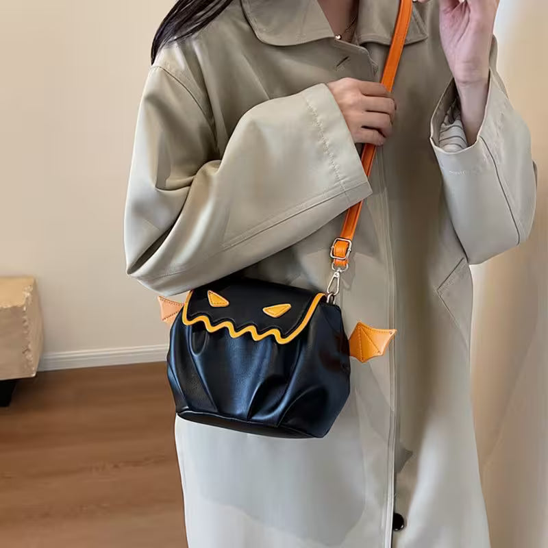 Person holding a black bag with orange accents, wearing a beige coat indoors.