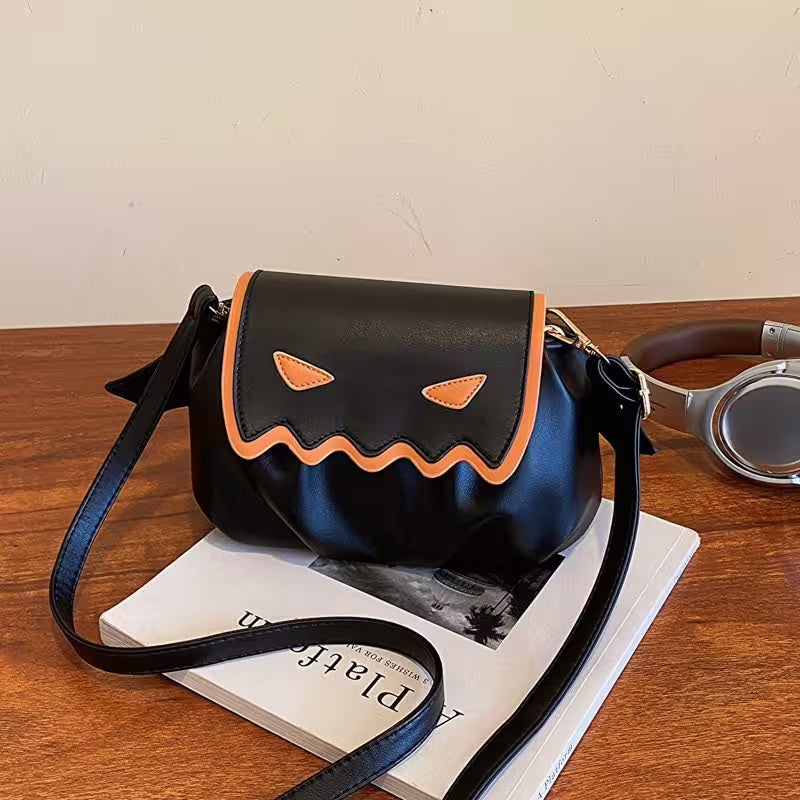 Black Halloween-themed bag with orange accents on a wooden surface