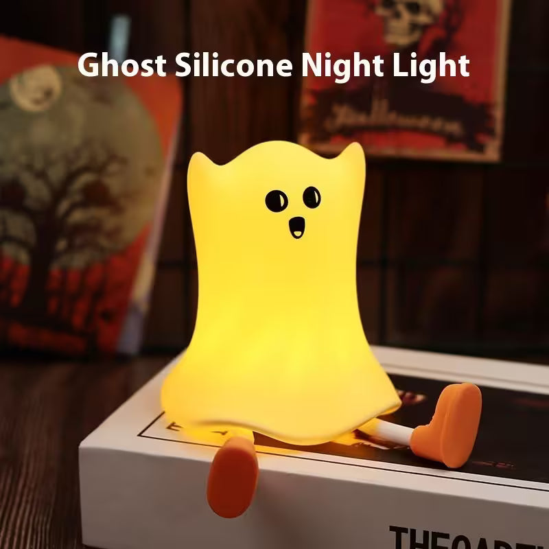 Ghost silicone night light on a surface with Halloween-themed decorations in the background
