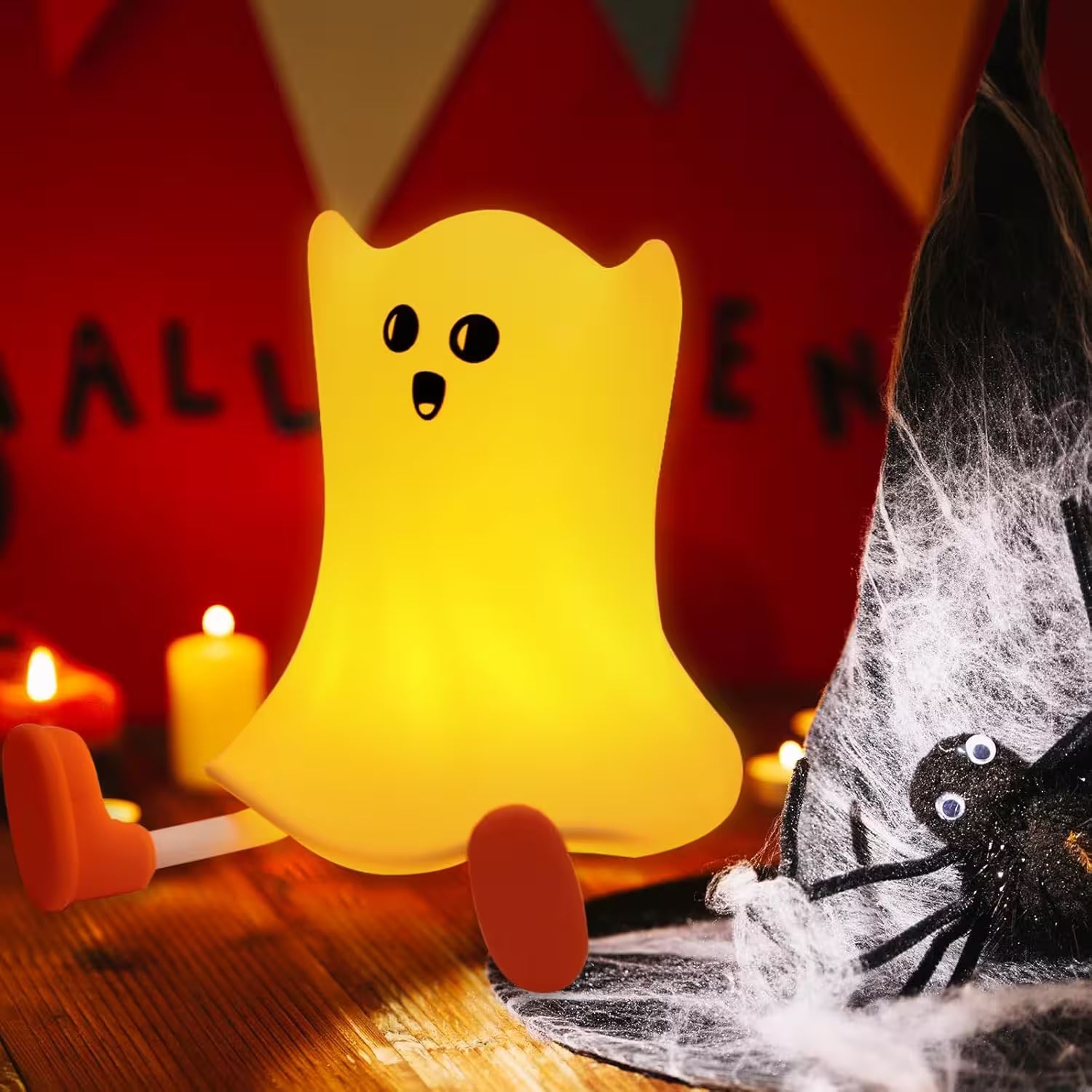 Yellow ghost-shaped lamp with black eyes and mouth on a Halloween-themed background.