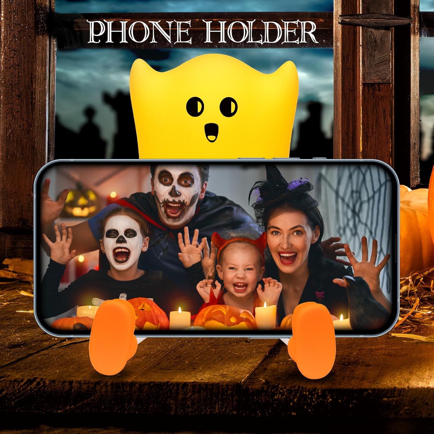 Phone holder with Halloween theme featuring a family and pumpkins on a wooden background.