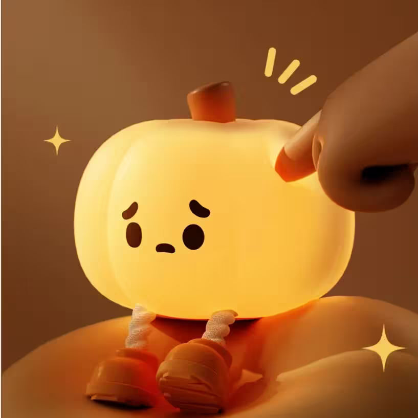 Cute pumpkin-shaped night light with a cartoon face on a brown background