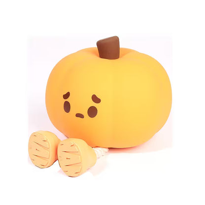 Plush toy pumpkin with a sad face on a white background