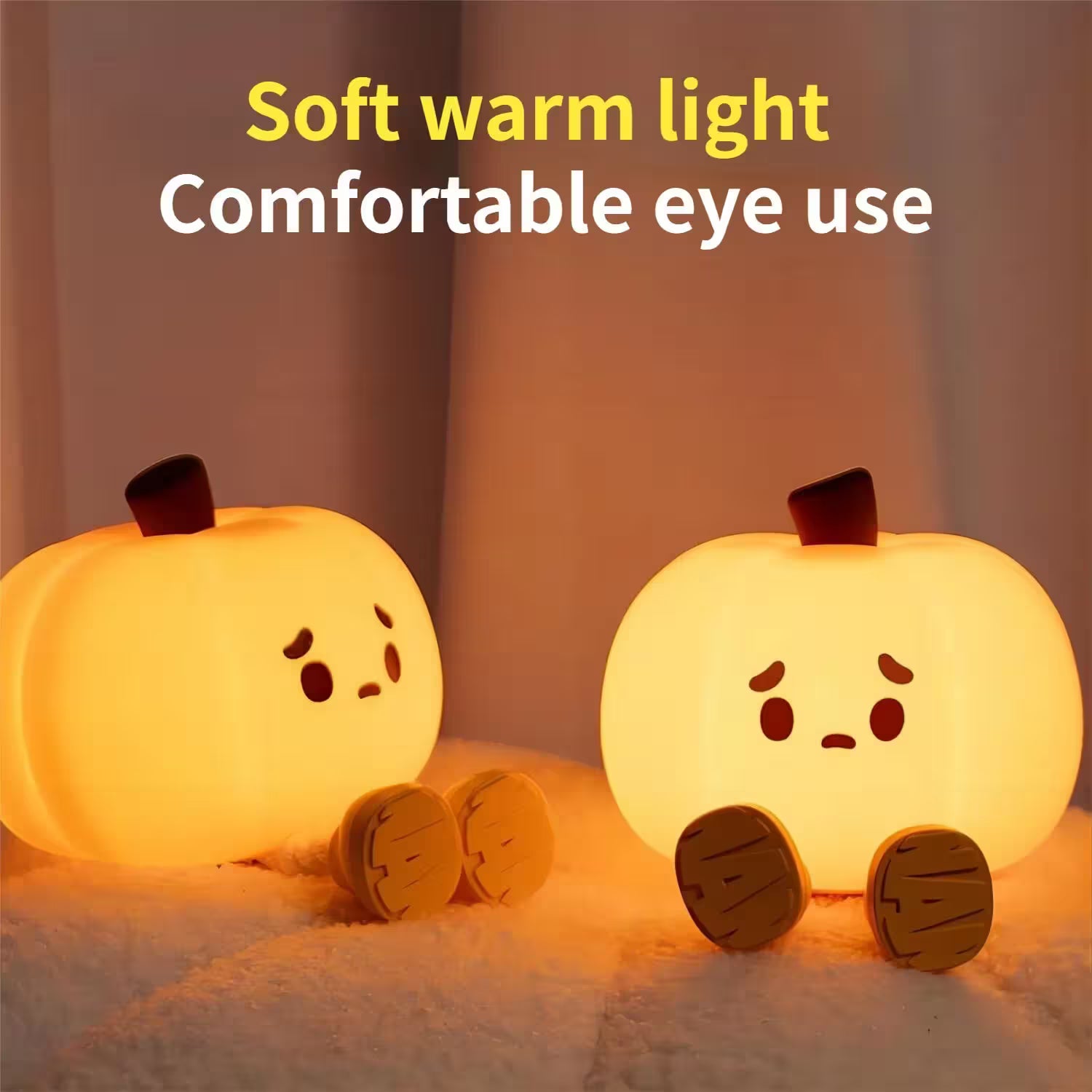 Two pumpkin-shaped night lights emitting a soft warm light on a neutral background.