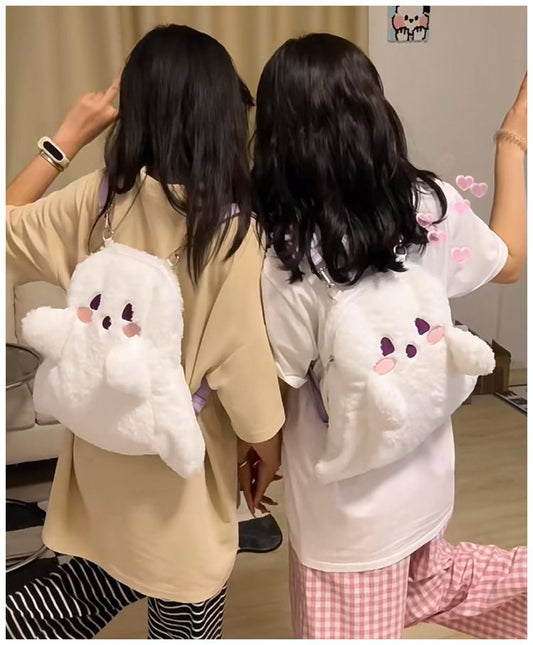 Two people wearing plush backpacks shaped like cartoon characters indoors.
