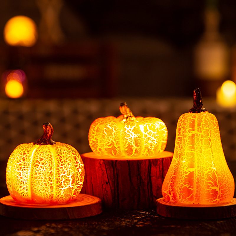 Three illuminated pumpkin-shaped lamps on a dark background with warm lighting.