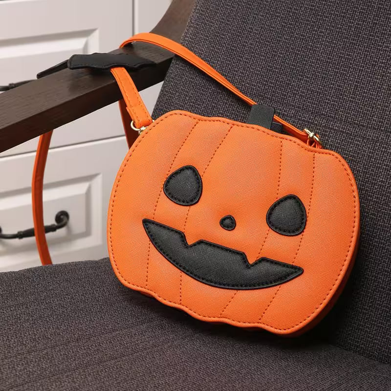 Orange pumpkin-shaped bag with a black face on a dark surface.