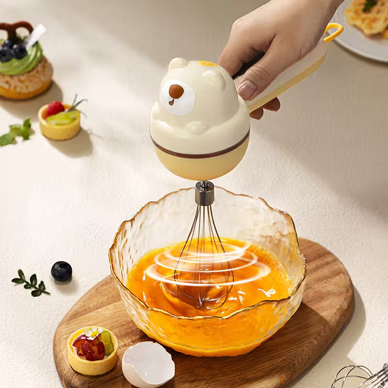 Hand using a cartoon-themed whisk to mix eggs in a glass bowl on a wooden cutting board.