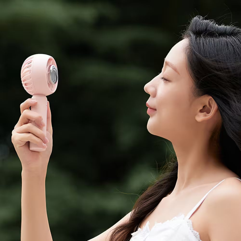 Woman holding a pink handheld device against a blurred green background