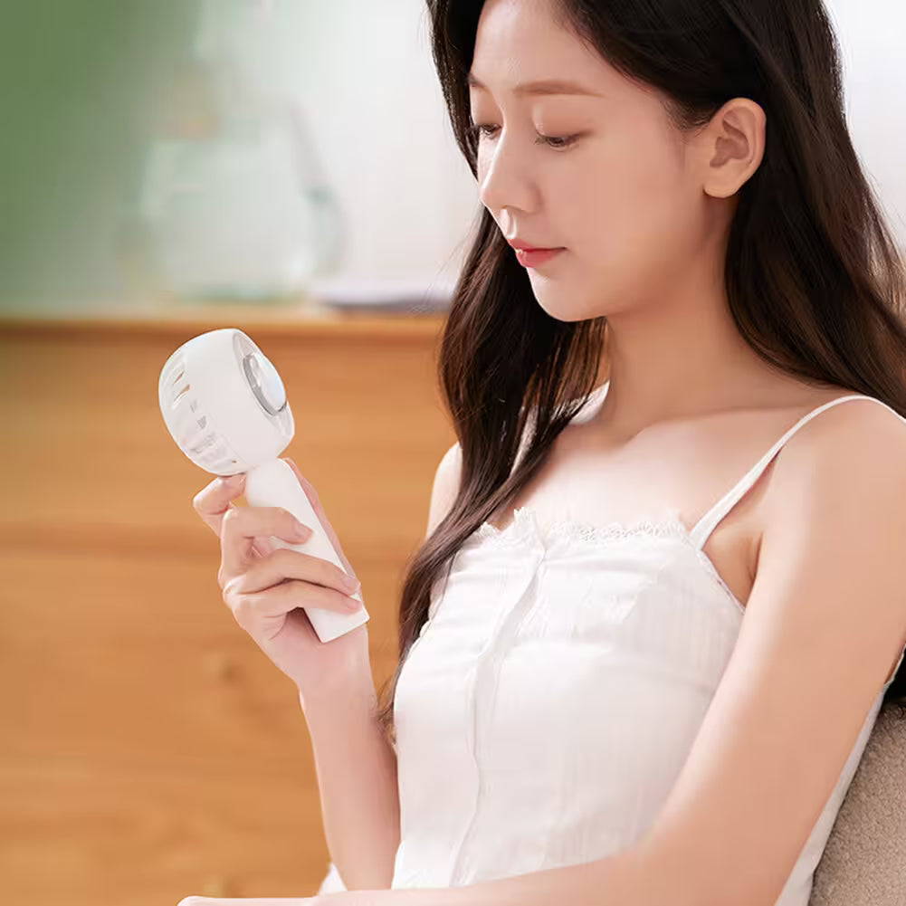 Woman holding a white handheld device in a blurred indoor setting