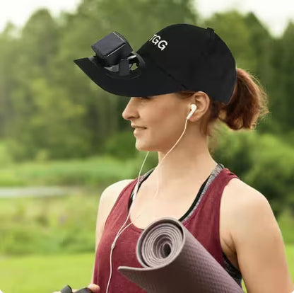 Woman holding a yoga mat outdoors with a cap on her head
